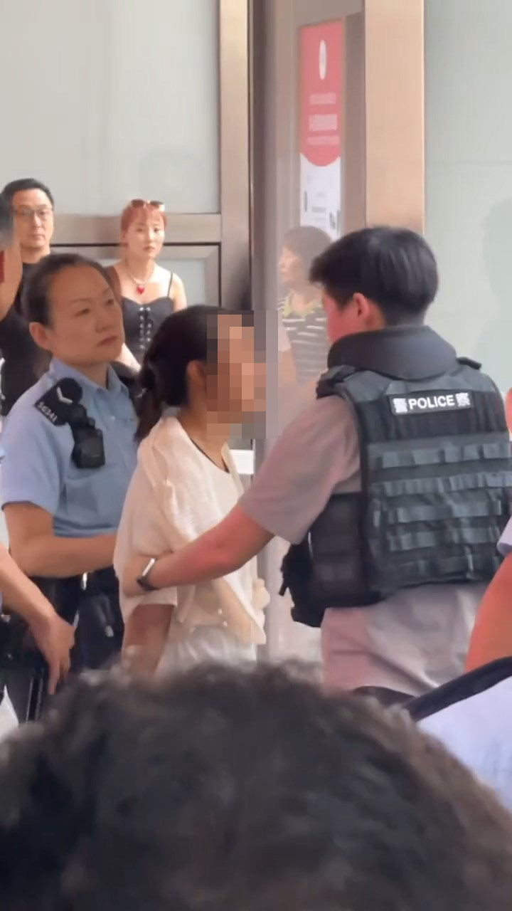 女子站起接受警方的盤問。 女子站起接受警方的盤問。