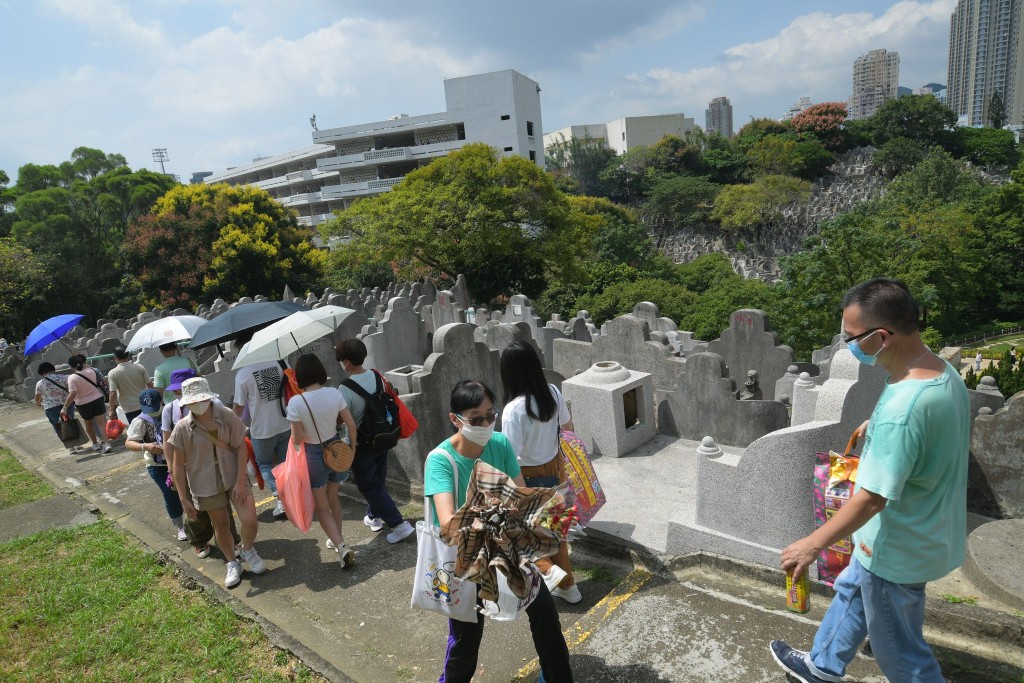 今日天氣酷熱，在鑽石山墳場，有掃墓的市民張開傘子遮擋艷陽。