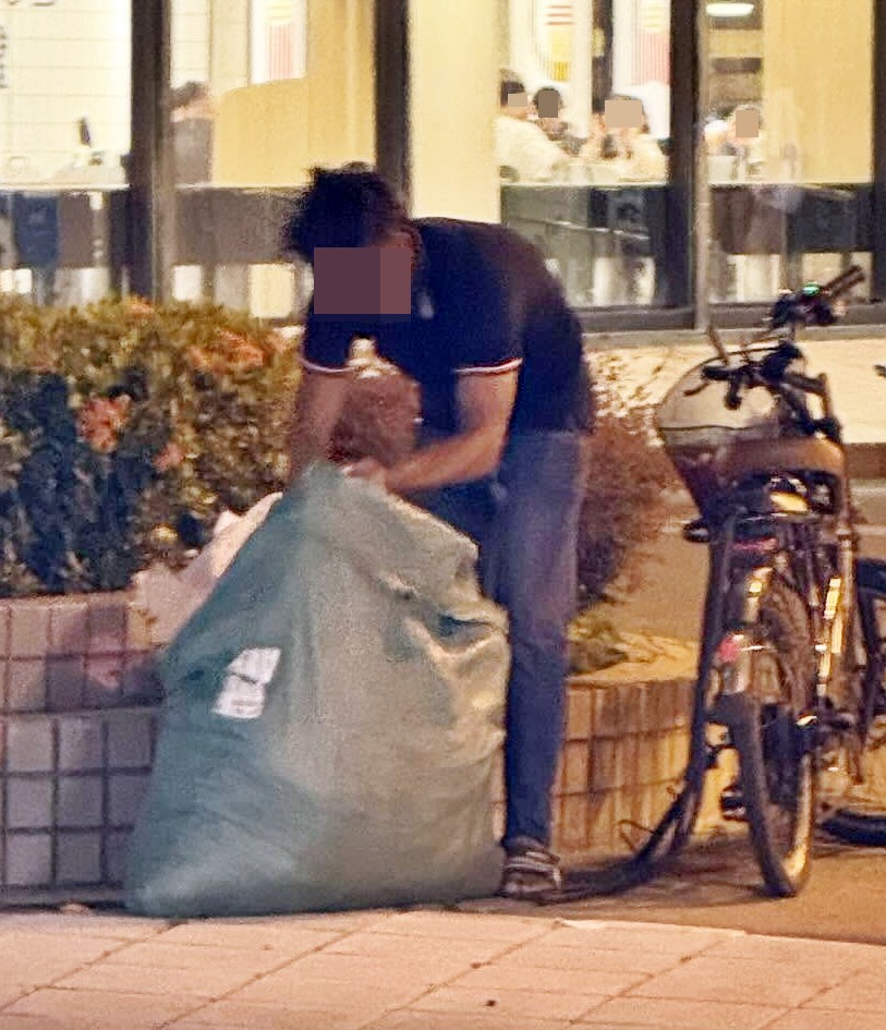 另一張照片，相信是涉事的男子在天瑞 商場一快餐店對出，埋首整理麻包袋內 滿載的疑似布料物品。Threads截圖