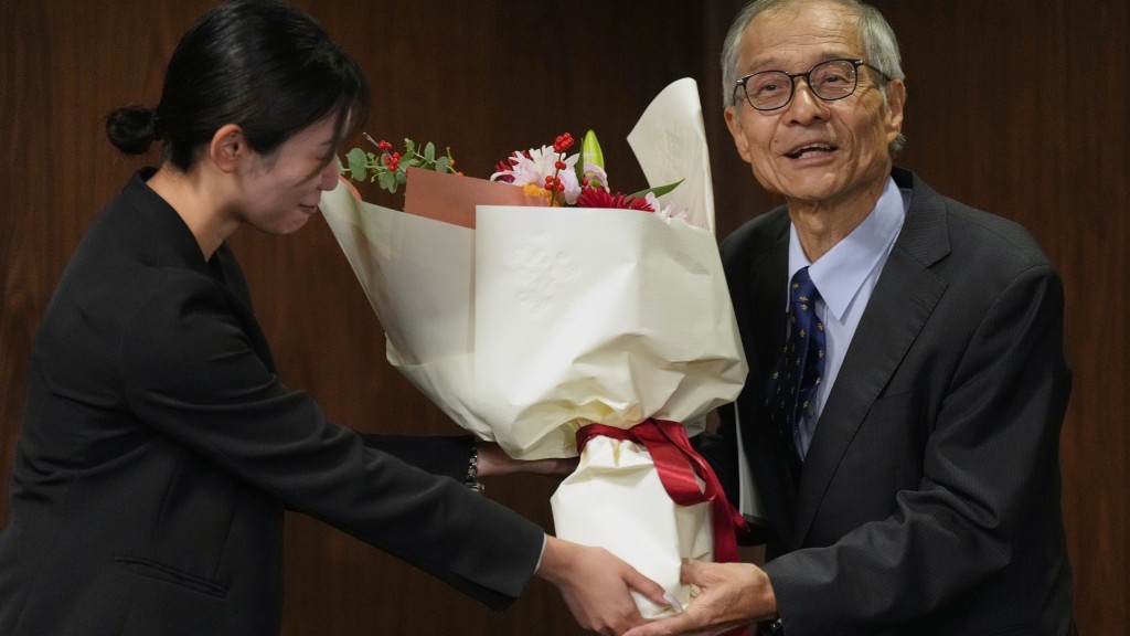 职员代表大学向硖合宪三献花。 美联社 职员代表大学向硖合宪三献花。 美联社