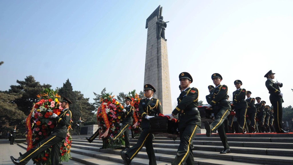禮兵護送志願軍烈士遺骸棺槨進行安葬。新華社