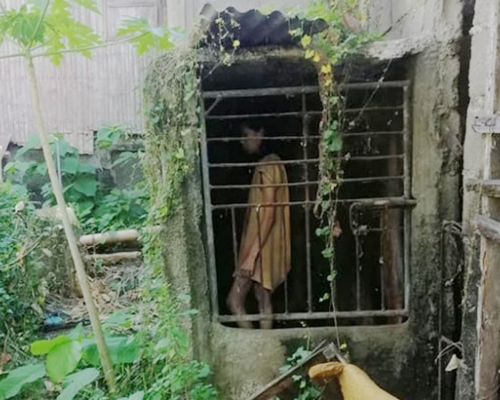 穿著黃色衣服的女子被關在鐵籠內25年。（FB圖片）