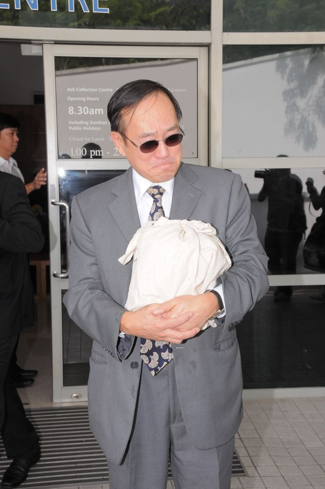 刘志敏拥亡妻骨灰难忍悲伤。（资料图片）