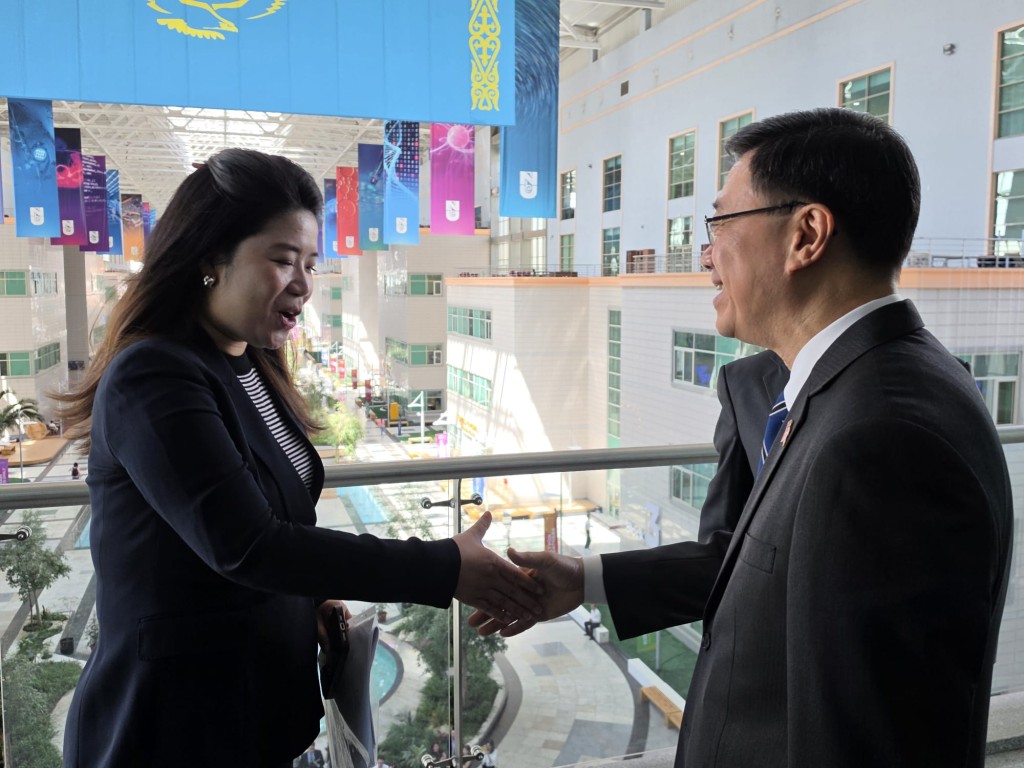 李家超與納扎爾巴耶夫大學電氣與計算機工程系副教授吳玥握手。虎報圖片