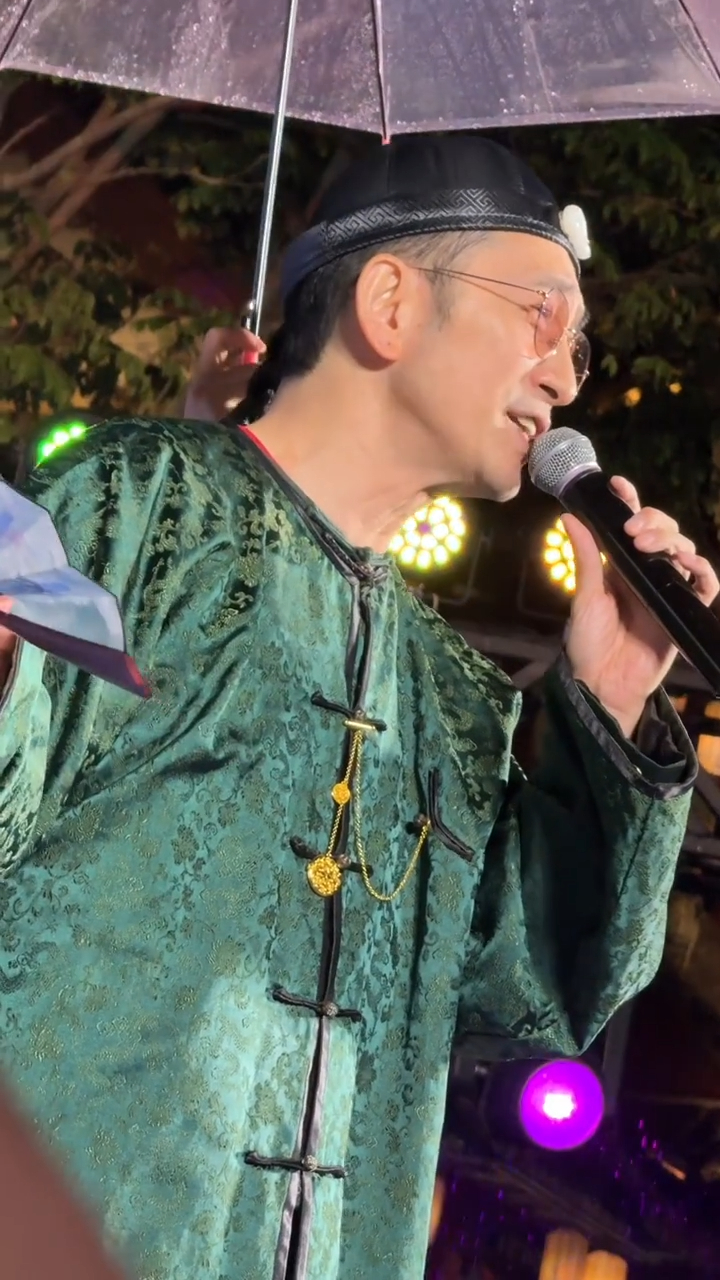 近日吳啟華身穿「方唐鏡」經典綠色清裝,在雨中敬業演唱。 近日吳啟華身穿「方唐鏡」經典綠色清裝,在雨中敬業演唱。