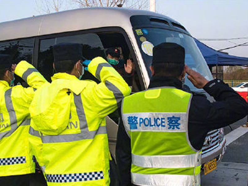 關卡執勤警員列隊敬禮,目送陝西國家緊急醫學救援隊離開。(新華社)