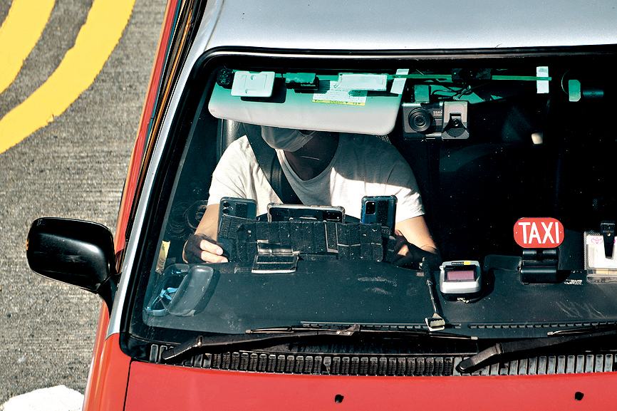 有的士司机在车头放置两部手机和一部平板电脑，涉嫌违例。 