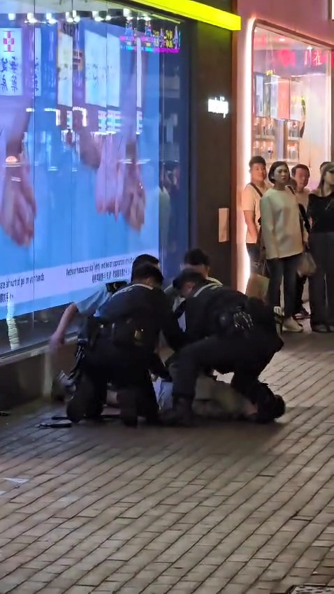 多名警員合力將被捕男子制服，按在地上。網上片段截圖