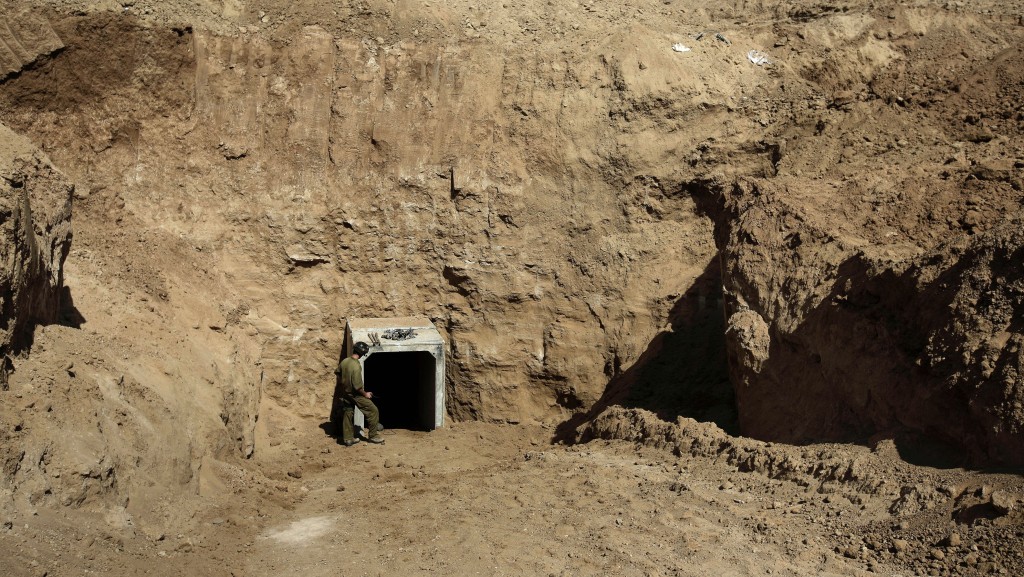 以色列士兵站在加沙边境附近发现的一处隧道出口。 美联社