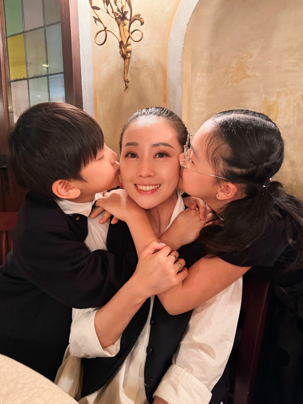 獲一對寶貝仔女左右夾攻送上「愛的獻吻」，任祉妍冧到甜笑。