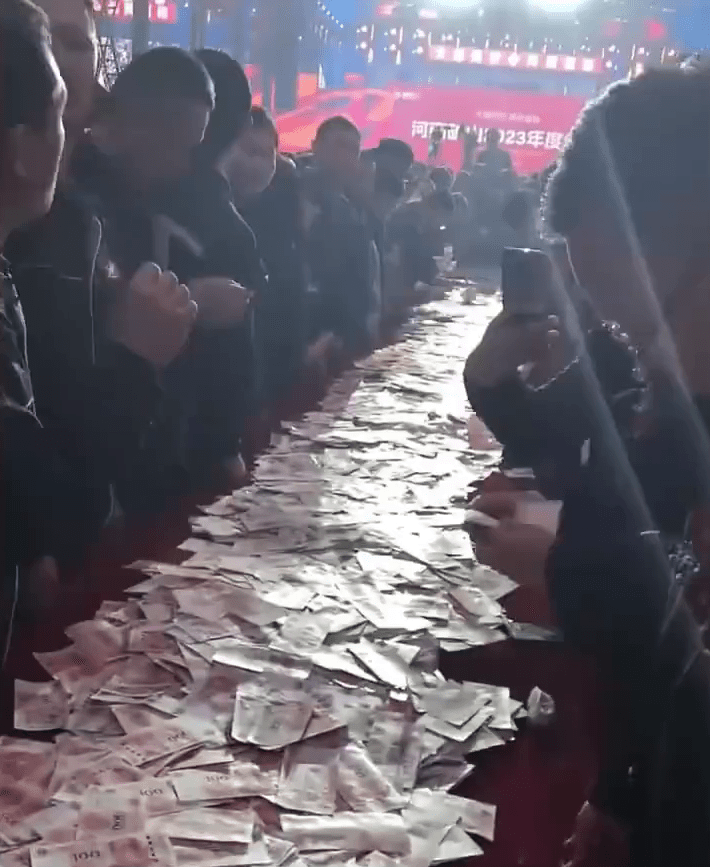 现场50米的长桌红布上铺满人民币现钞。