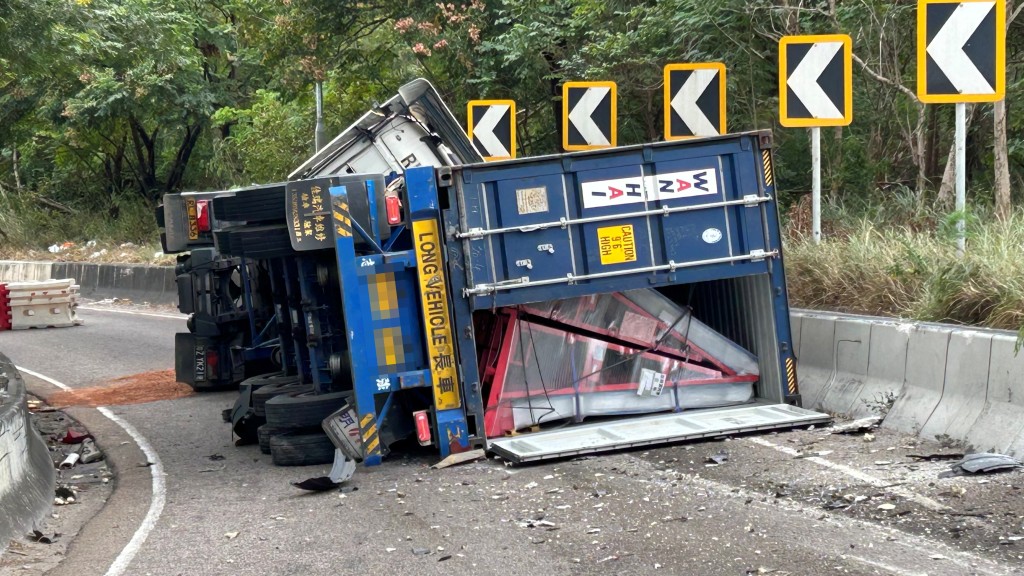 石壆瓦礫及貨車殘骸四散一地，貨斗內貨物翻側。蔡楚輝攝
