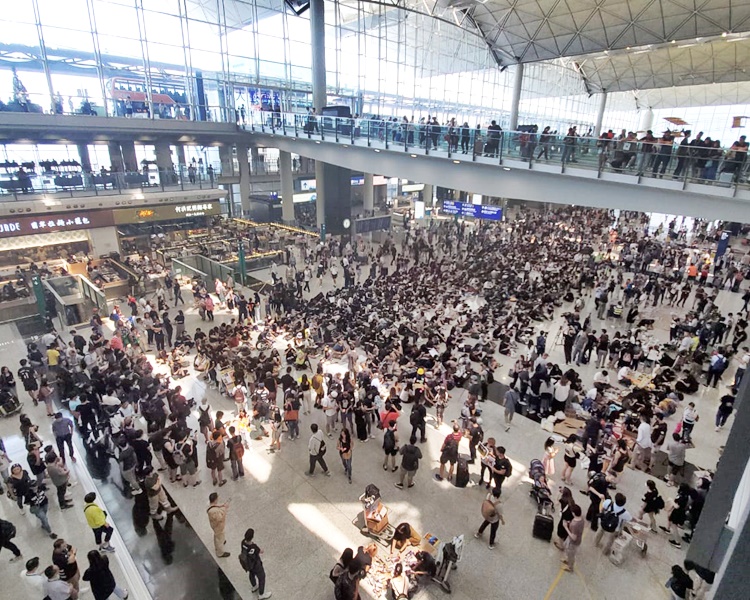 一批黑衣人在接机的抵港大堂静坐。