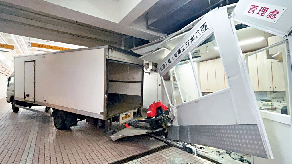 貨車尾板如刀片般直插入鋅鐵寫字樓內。