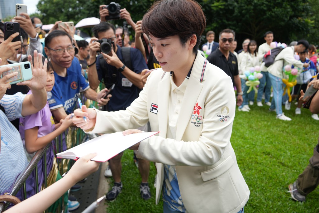 運動員為市民簽名合照留念。吳艷玲攝