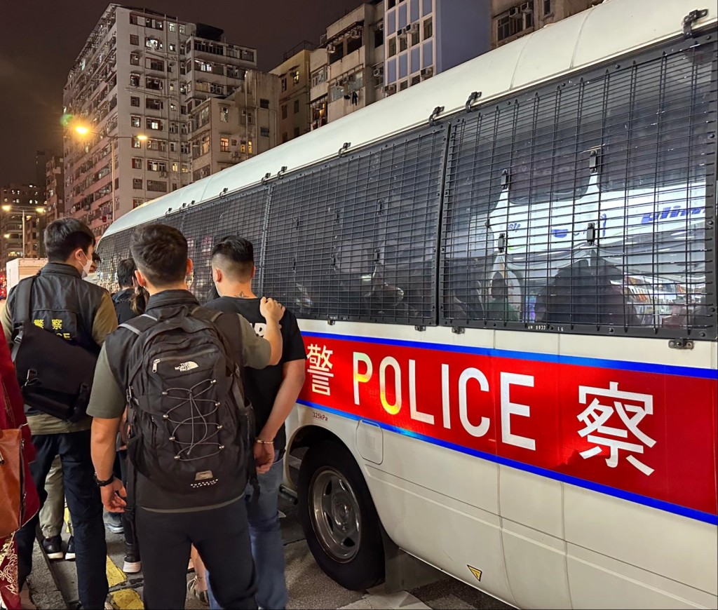 警員將被捕人士押上警車。