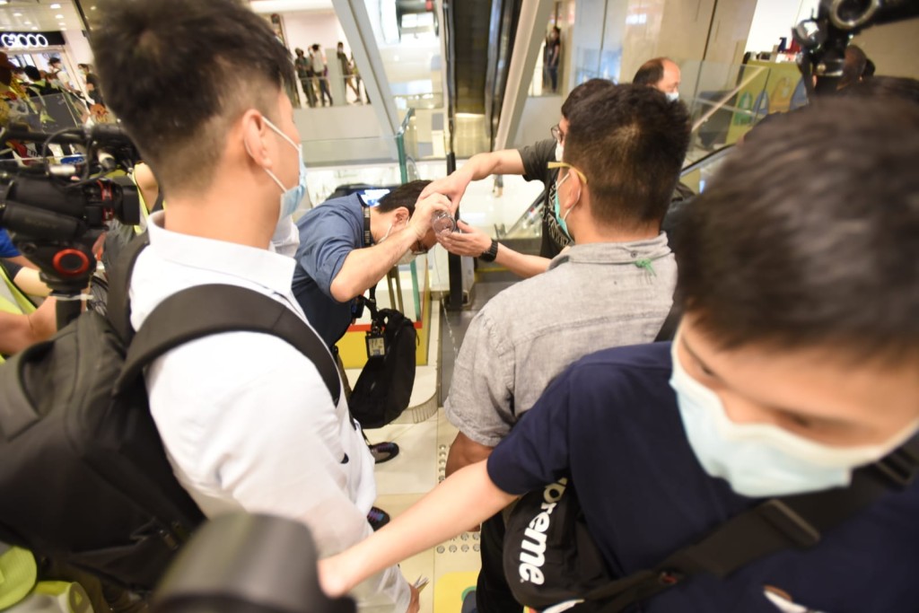 有便衣警員被擲水樽後要同袍冲洗。