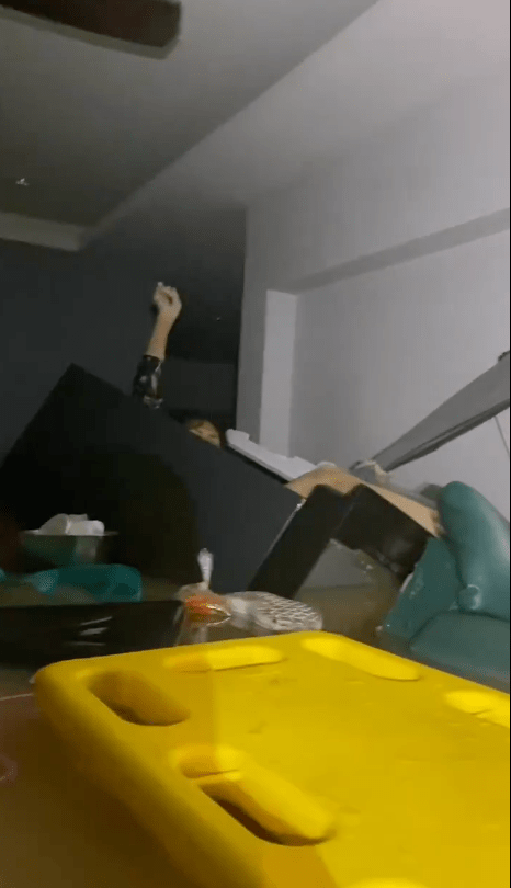 救援人員發現一個漂浮於急流中的冰箱，微弱燈光下，一名年約50歲的婦人虛弱地舉手示意求救。X@Mr_Whathapened