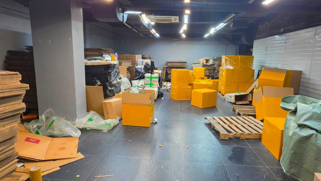 海關指被捕的內地男女在地舖內將私煙重新整理及包裝作下一步分銷。海關提供 海關指被捕的內地男女在地舖內將私煙重新整理及包裝作下一步分銷。海關提供