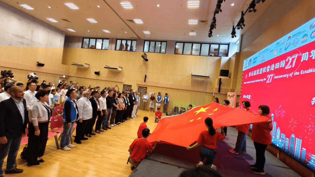 全體不同族裔參與者一同面向巨型國旗唱國歌，以祝賀香港回歸27週年。