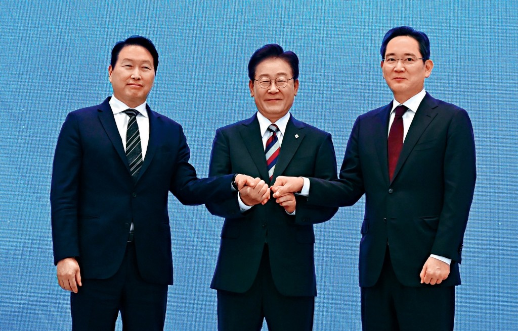 李在明(中)6月與三星電子會長李在鎔（右）、SK集團會長崔泰源宣布大投資計劃。 路透社
