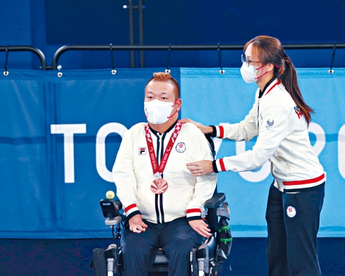 施珊珊為梁育榮掛上獎牌。