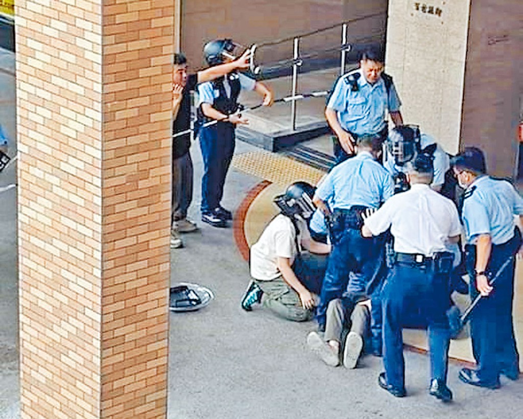 多名警員合力制服疑人並鎖上手銬。