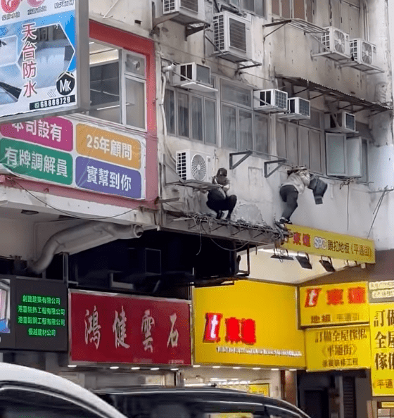 影片顯示，其中一名戴鴨舌帽、手挽一黑一白環保袋的男子，一度蹲在外牆冷氣分體機旁。Facebook「車cam L（香港群組）」（下同）