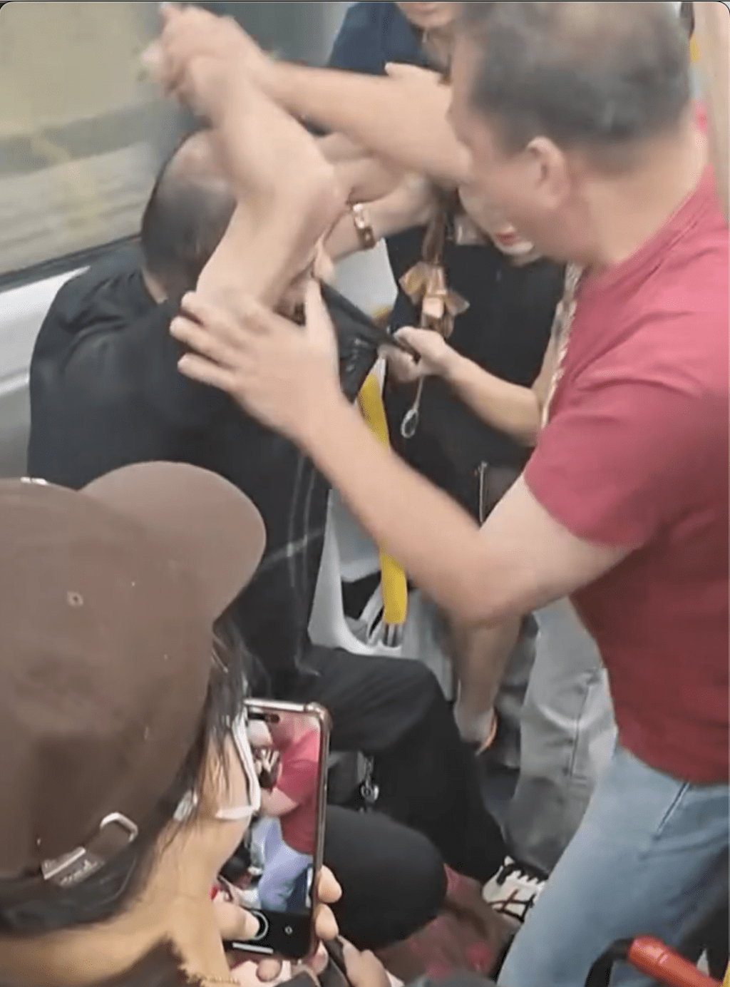 禿頭男被紅衣男壓在座位上。網片截圖 禿頭男被紅衣男壓在座位上。網片截圖