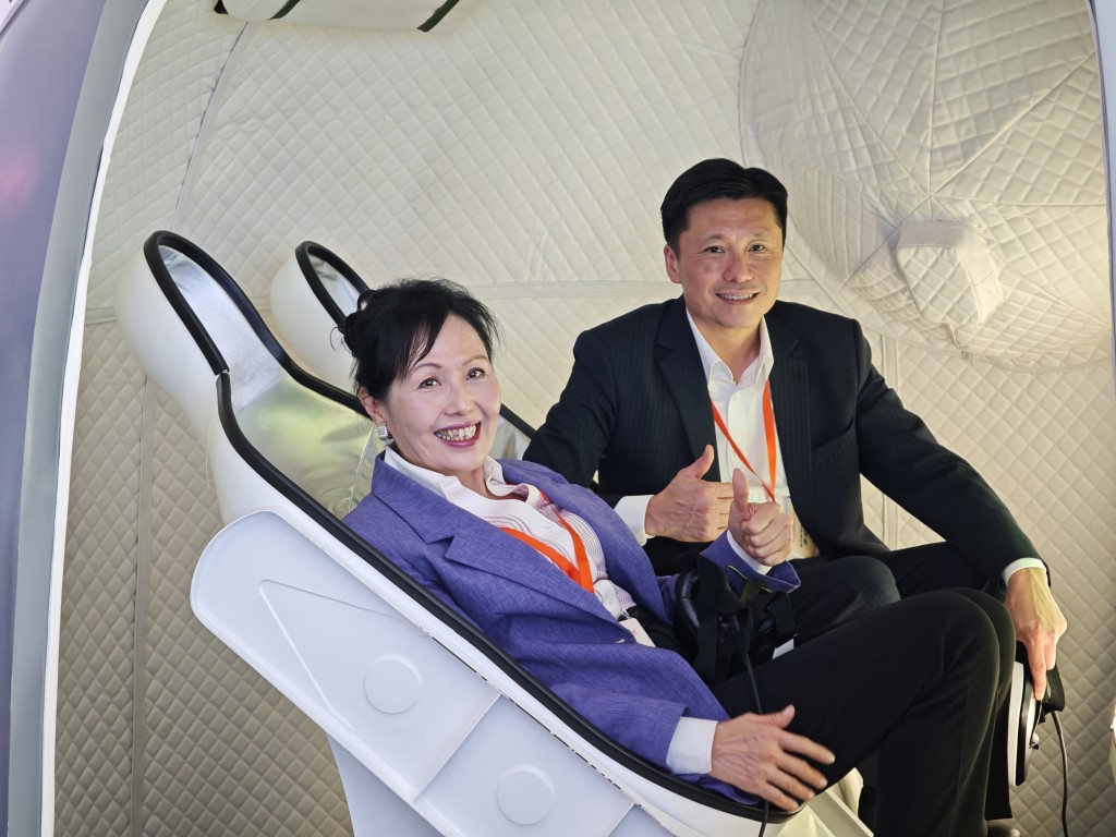 愛國主義教育工作小組組長陳清霞(左)及政府新聞處處長謝振中(右)登上「返回艙」,一嚐成為太空人的感覺。 愛國主義教育工作小組組長陳清霞(左)及政府新聞處處長謝振中(右)登上「返回艙」,一嚐成為太空人的感覺。