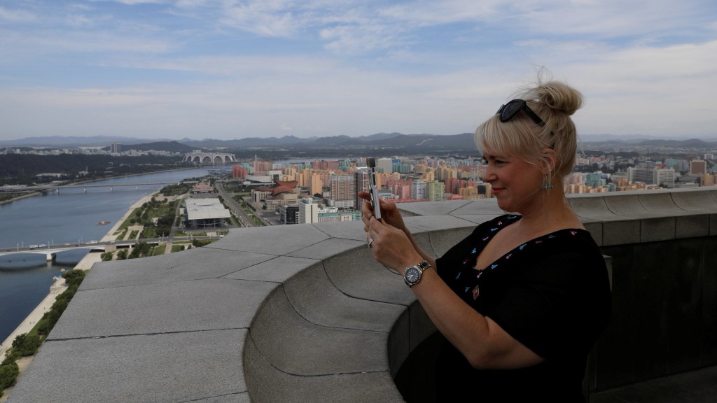 芬兰游客在平壤主体思想塔的观景台上拍摄城市天际线。 路透社
