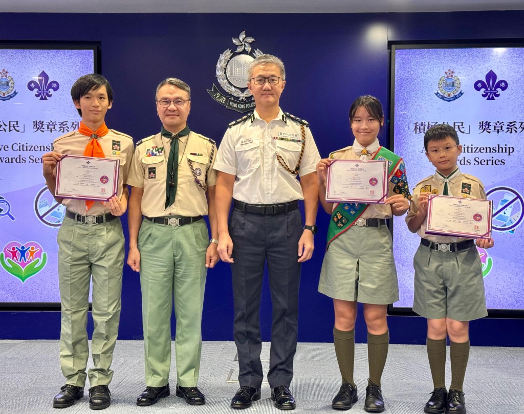 警務處處長蕭澤頤(中)、香港童軍總會香港總監黎偉生(左二)與3名完成「防騙先鋒章」的童軍成員黃晉軒(左一)、黃樂晴(右二)、梁桀朗(右一)留影。 麥鍵瀧攝