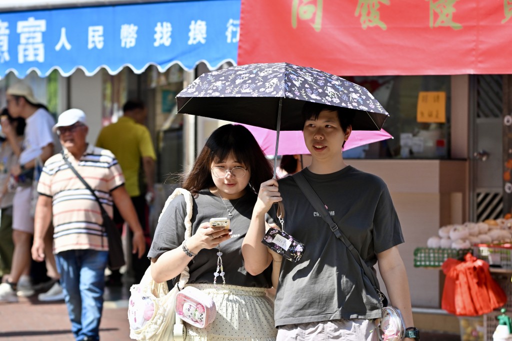 市民紛撐起太陽傘防曬。劉駿軒攝 市民紛撐起太陽傘防曬。劉駿軒攝