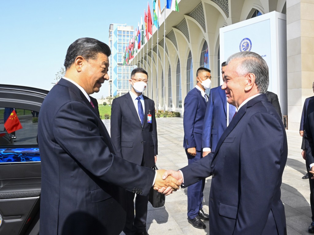 習近平乘車抵達國際會議中心，米爾濟約耶夫在下車處熱情迎接。 新華社