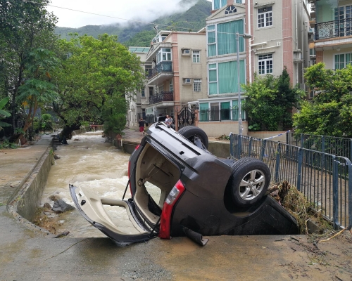 私家車被洪水沖到石橋下。