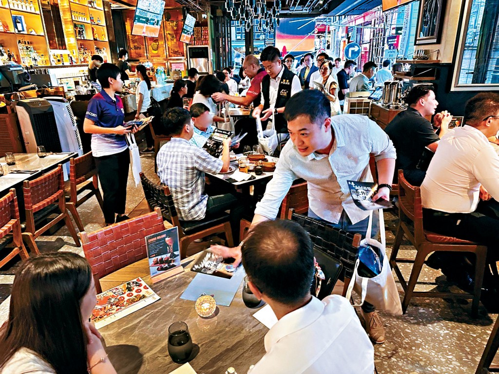 不少酒吧期望在世界杯期间增加生意。图为警方在兰桂坊派发传单，提醒市民不要参与外围赌博。