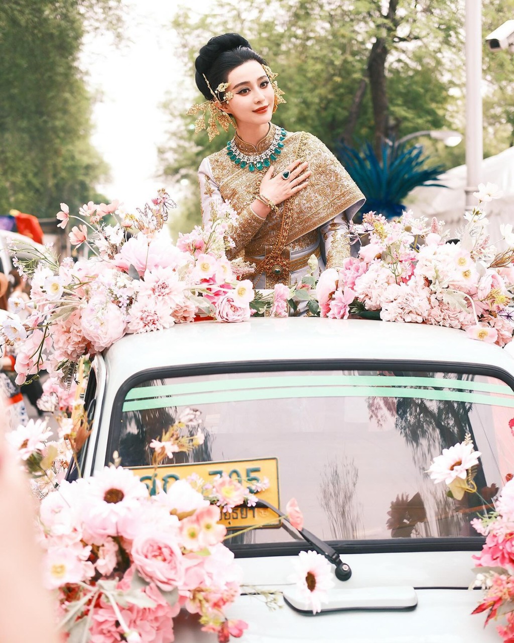 照片中可见，范冰冰穿上泰国传统服饰，站在车上出巡，摆出不少Pose，泰味十足。