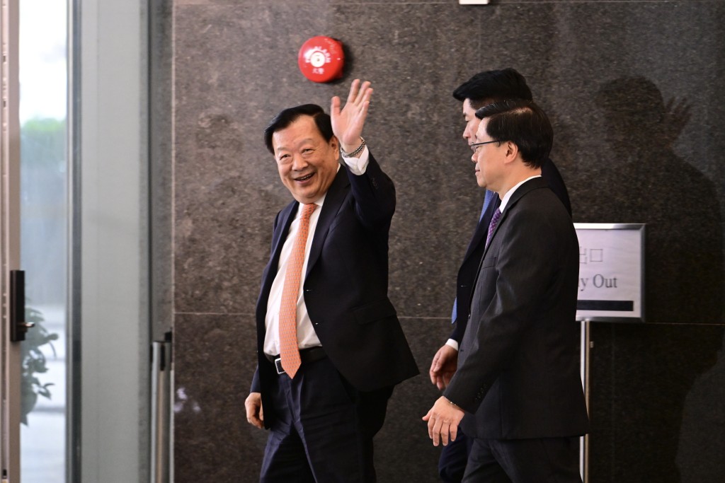 夏宝龙（左）离开政总，期间向传媒挥手示好。陈极彰摄