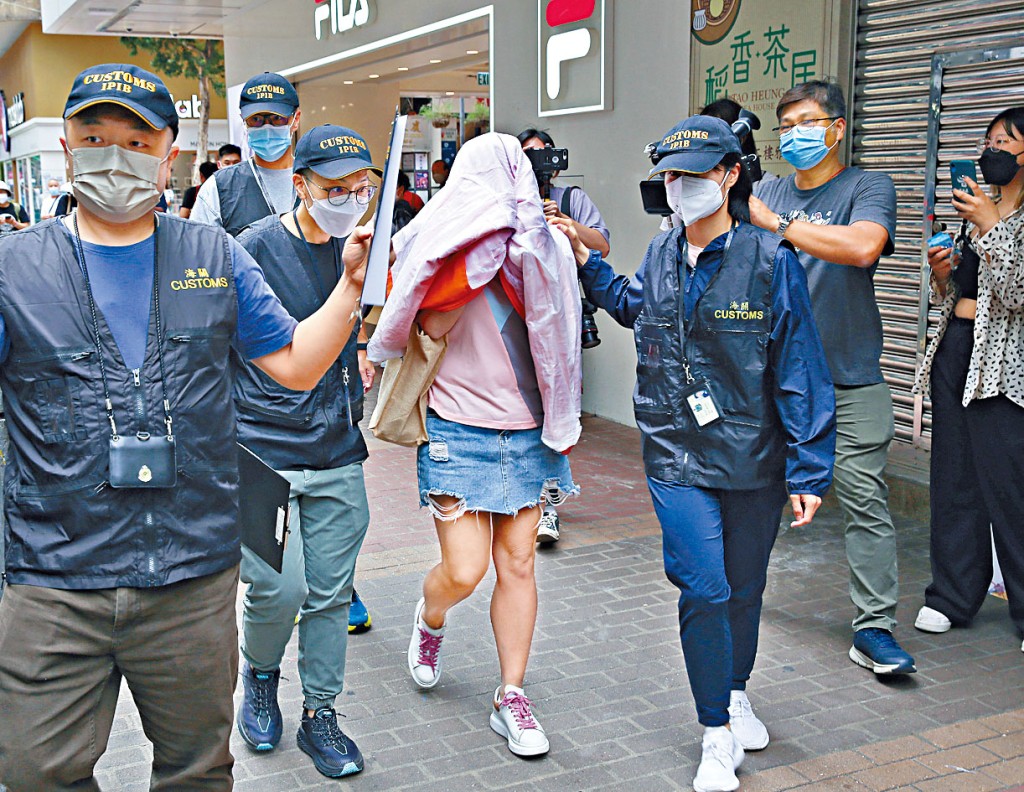 海關拘捕涉案僱傭中介女職員（中）。