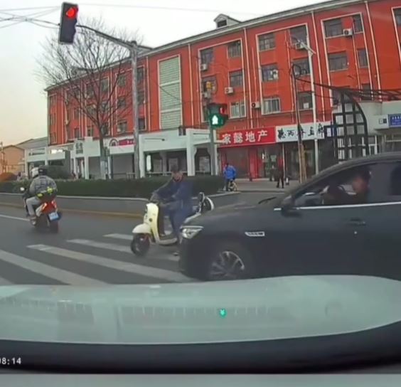 黑色车司机不满女事主停车让路人，举中指挑衅，却撞到一名骑电动车的大叔。