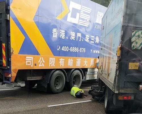 電單車被捲入其中一輛貨車車底，鐵騎士倒地受傷。Alex Chan圖片。網圖