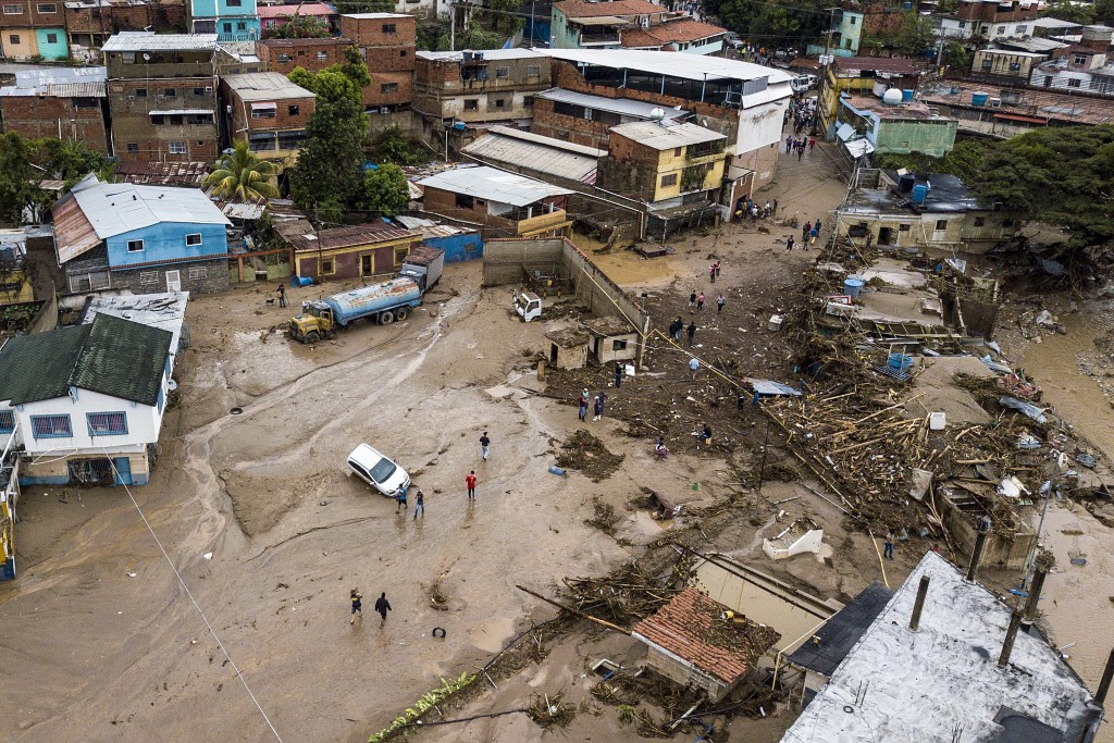 居民在委內瑞拉拉斯泰赫里亞斯的洪水區行走。AP