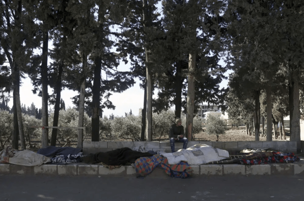 敘利亞阿勒頗省金德里斯鎮，一名男子坐在地震中喪生的家人的屍體旁邊。AP