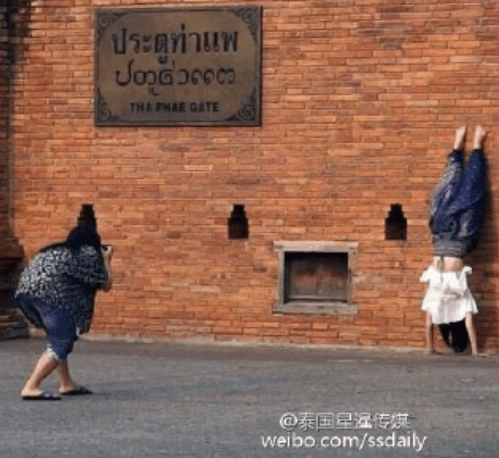 2016年,有兩名中國女遊客在古城牆邊游玩拍照,其中一名女遊客以倒立的姿勢,將腳靠在了古城上,事件引來過路民眾議論紛紛。圖:泰國星暹傳媒 2016年,有兩名中國女遊客在古城牆邊游玩拍照,其中一名女遊客以倒立的姿勢,將腳靠在了古城上,事件引來過路民眾議論紛紛。圖:泰國星暹傳媒