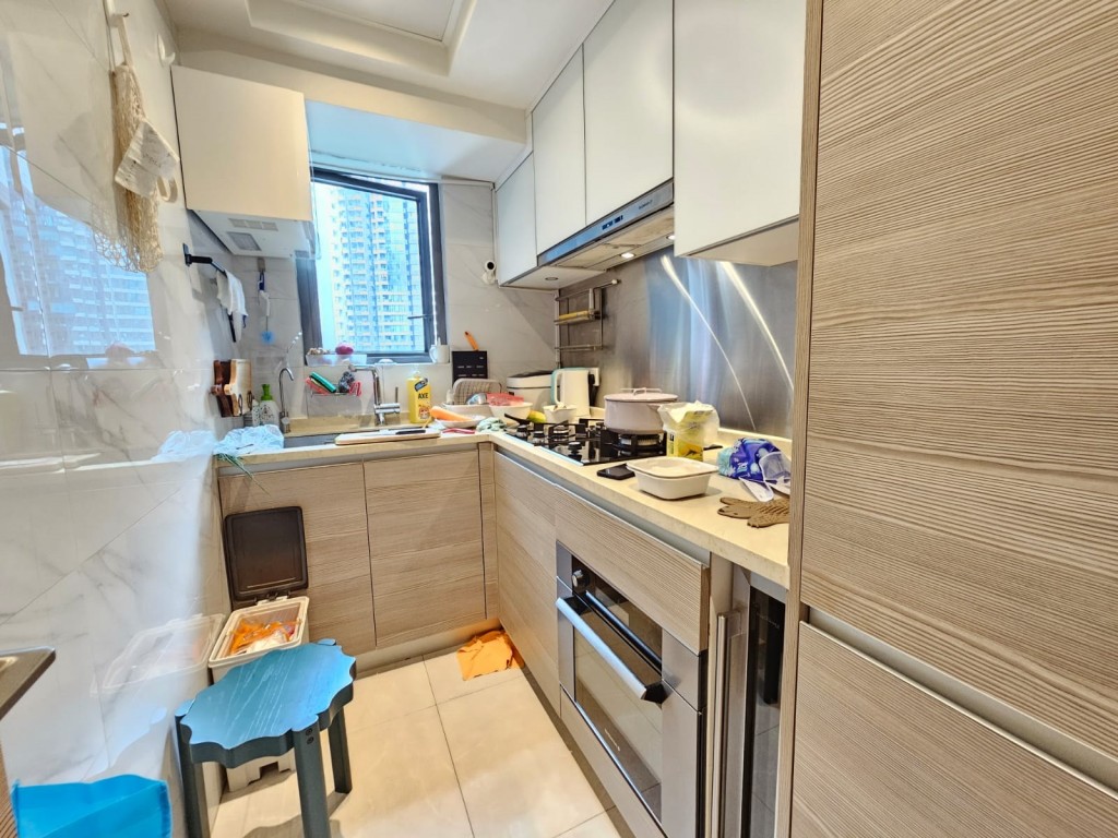廚房有木色廚櫃，附有不少嵌入式家電。 