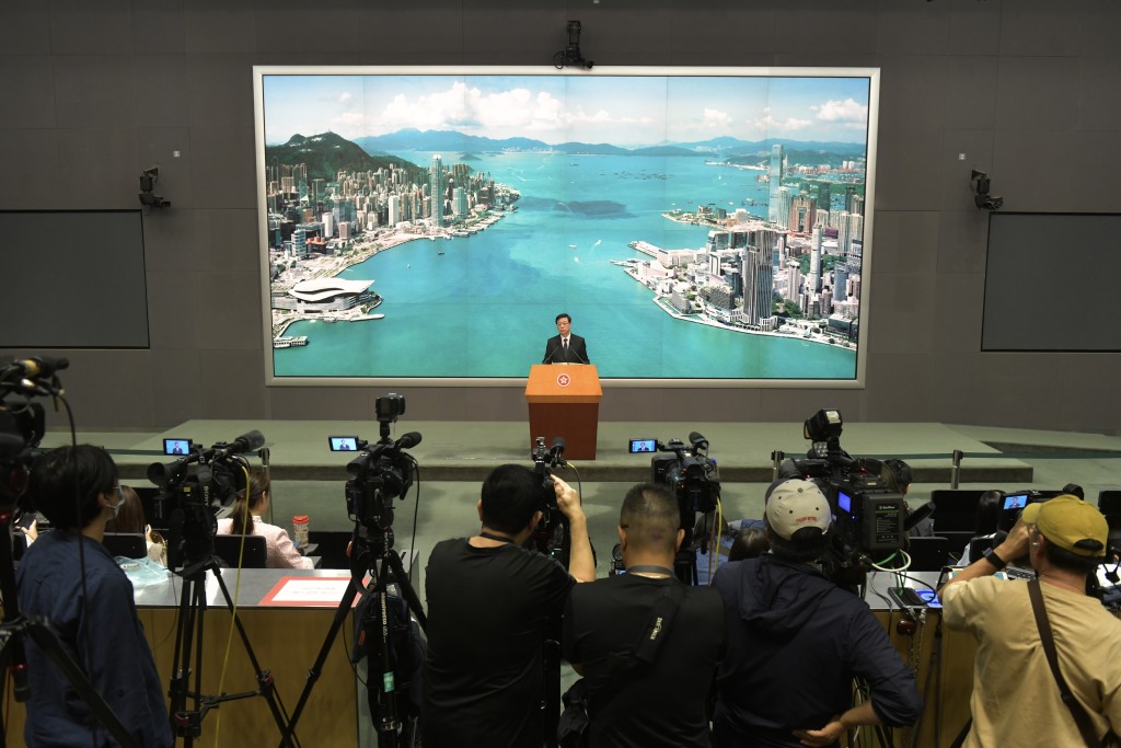 特首李家超见记者，记者会使用维港作为背景主题。（陈极彰摄）