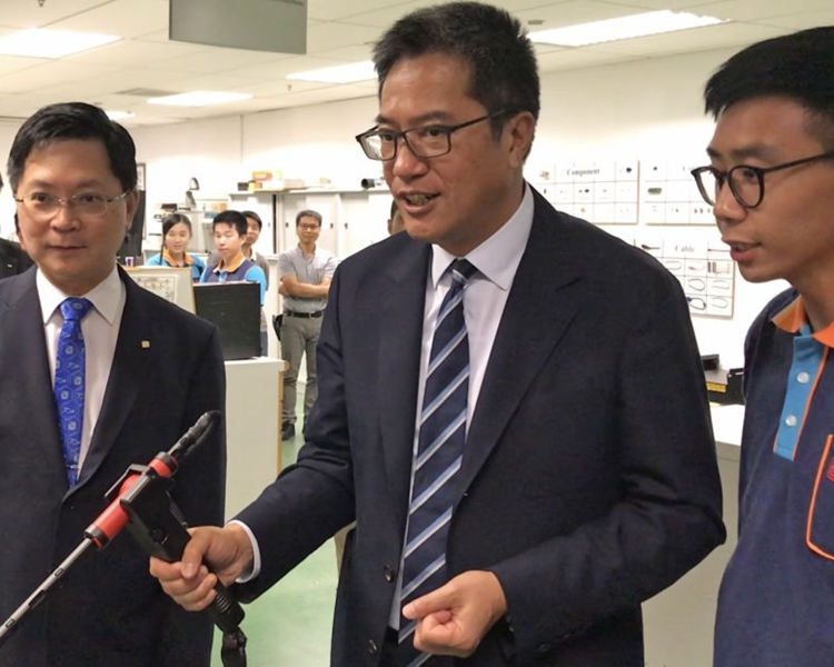 學員向黃偉綸介紹如何使用焊接訓練模擬器。