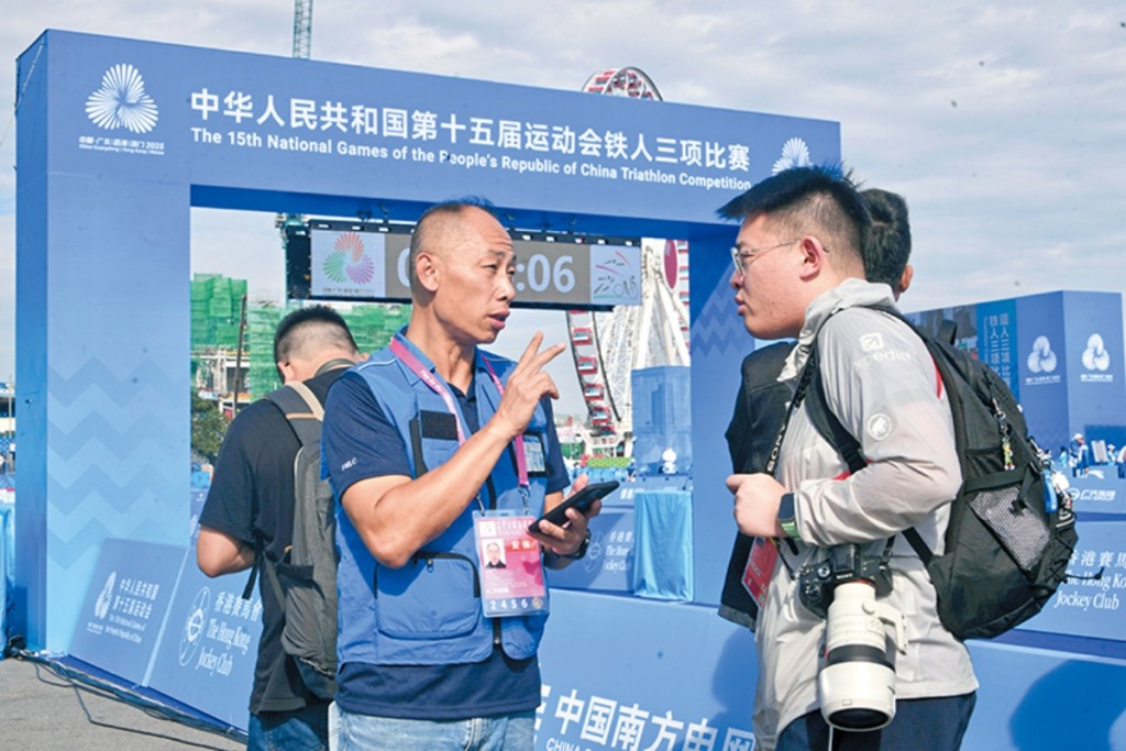 鍾敬威（右二）於第十五屆全國運動會中協助傳媒採訪。