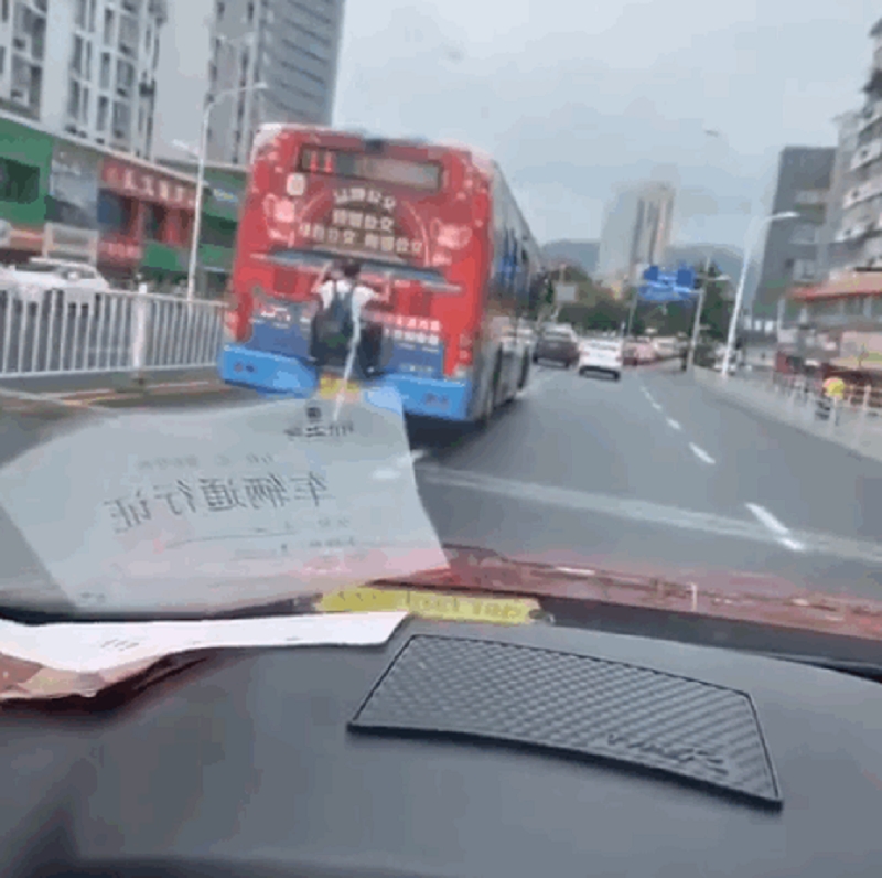 男子趴在巴士車尾。網上圖片