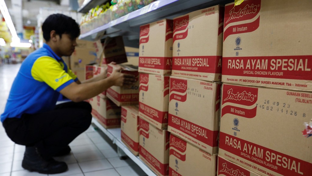 在印尼耶加达，超市职员正在整理一箱箱「营多」（Indomie）特色鸡肉风味即食面。 路透社